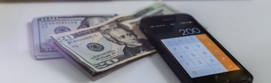 שטרות ואייפון עם מחשבון על שולחן