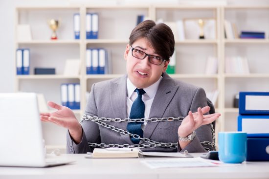 אדם בחליפה וחלצה מכופתרת עם ידיים קשורות באמצעות שרשראות